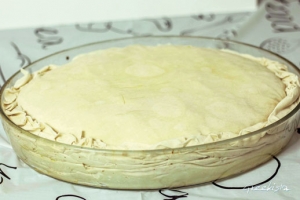 Ολοκληρώνουμε την συναρμολόγηση, διπλώνοντας τις άκρες των εξωτερικών φύλλων μέσα στο ταψί. Αλείφουμε όλη την επιφάνεια με λίγο λάδι και με τα δάχτυλα αλείφουμε και λίγο νεράκι από πάνω για να γίνει πιο τραγανή η κρούστα.